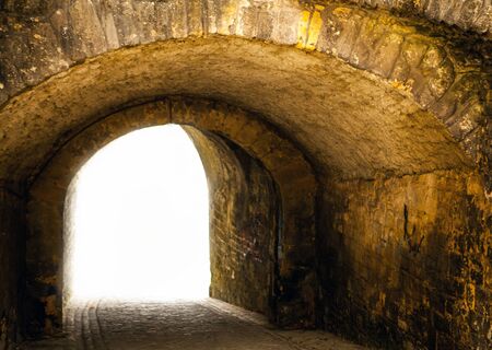 Stone tunnel leading to bright light.