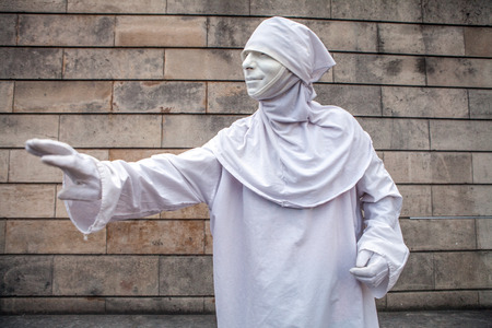 Street performance of actor stylized in white clothes and mask.のeditorial素材