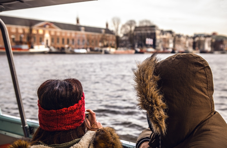 Young couple traveling by boat on canals of Amsterdam.の写真素材