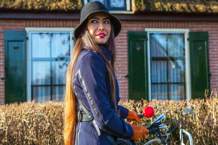 Outdoors portrait of attractive young woman with white bicycleの写真素材