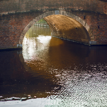 Ancient stone bridge through river in Hague.の写真素材
