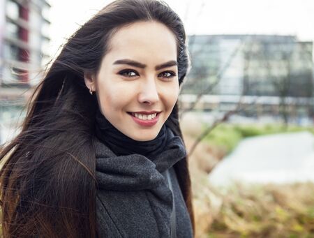 Attractive young woman with long beautiful hairs posing outdoor.