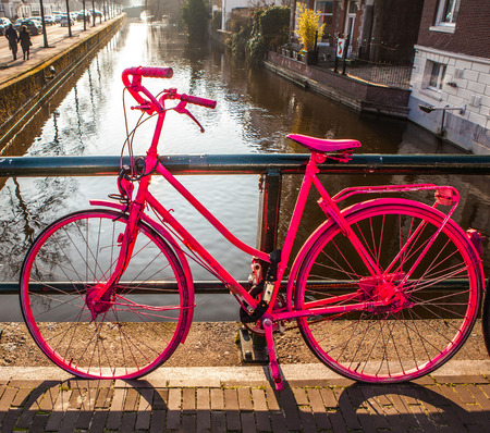 Parked in city street bright pink bicycles on sunny evenig close-up.の写真素材
