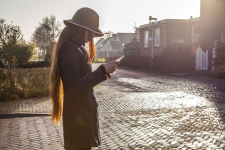 Outdoors portrait of attractive young woman with long beautiful hairs and city map in hands.の写真素材