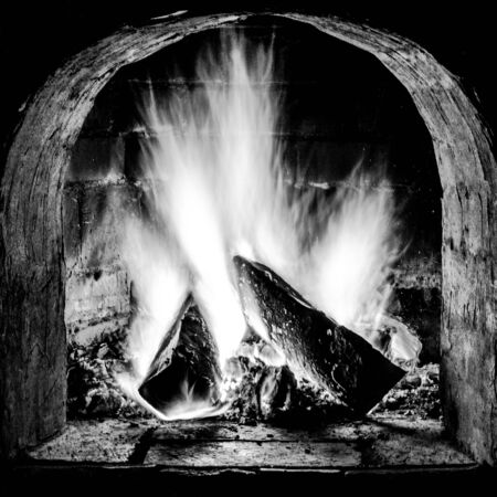 Fireplace with a blazing fire. Black-white photo.の写真素材