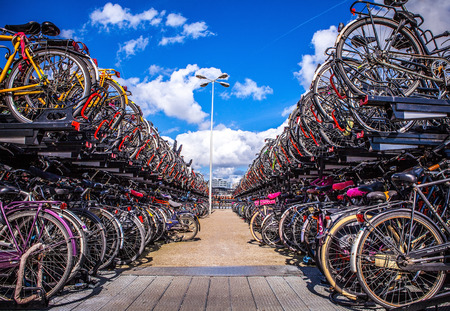 AMSTERDAM, NETHERLANDS - AUGUST 15, 2016: Two-level parking of bicycles in Amsterdam city. Amsterdam...