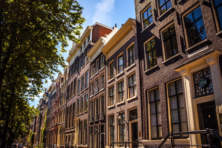 AMSTERDAM, NETHERLANDS - AUGUST 15, 2016: Famous buildings of Amsterdam city centre close-up. General landscape view of city streets and traditional Dutch architecture. Amsterdam - Netherlands.のeditorial素材