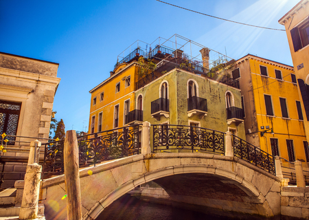 VENICE, ITALY - AUGUST 21, 2016: View on the cityscape and lovely bridge on the canal of Venice on August 21, 2016 in Venice, Italy.のeditorial素材