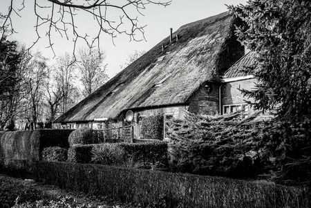 GIETHOORN, NETHERLANDS - JANUARY 20, 2016: Black-white photo of old cozy house with thatched roof on January 20, 2016 in Giethoorn, Netherlands.のeditorial素材