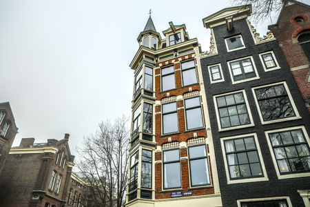 AMSTERDAM, NETHERLANDS - DECEMBER 28, 2016: Famous buildings and place of Amsterdam city centre at sun set time. General landscape view. December 28, 2016 - Amsterdam - Netherlands.のeditorial素材