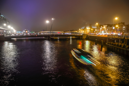 AMSTERDAM, NETHERLANDS - JANUARY 02, 2017: Cruise boat in night canals of Amsterdam. January 02, 2017 in Amsterdam - Netherland.のeditorial素材