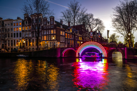 AMSTERDAM, NETHERLANDS - JANUARY 10, 2017: Cruise boats rush in night canals. Light installations on night canals of Amsterdam within Light Festival. January 10, 2017 in Amsterdam - Netherland.のeditorial素材