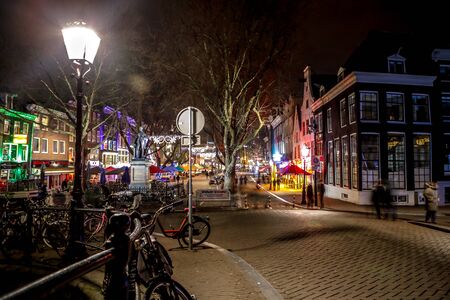 AMSTERDAM, NETHERLANDS - JANUARY 07, 2017: Night streets of Amsterdam with blurred silhouettes of passersby on January 07, 2017 in Amsterdam - Netherland.のeditorial素材