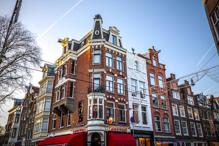 AMSTERDAM, NETHERLANDS - JANUARY 09, 2017: Famous vintage buildings of Amsterdam city at sun set. General landscape view at tradition Dutch architecture. January 09, 2017 - Amsterdam - Netherlands.のeditorial素材