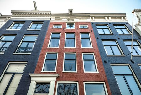 AMSTERDAM, NETHERLANDS - JANUARY 09, 2017: Famous vintage buildings of Amsterdam city at sun set. General landscape view at tradition Dutch architecture. January 09, 2017 - Amsterdam - Netherlands.のeditorial素材