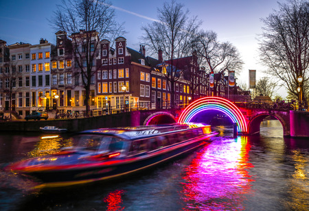 AMSTERDAM, NETHERLANDS - JANUARY 10, 2017: Cruise boats rush in night canals. Light installations on night canals of Amsterdam within Light Festival. January 10, 2017 in Amsterdam - Netherland.のeditorial素材