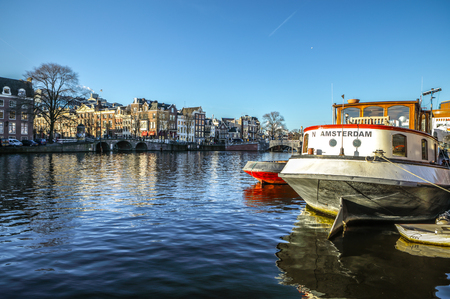 AMSTERDAM, NETHERLANDS - JANUARY 09, 2017: Boats on water in beautiful evening sun set. January 09, 2017 in Amsterdam - Netherland.のeditorial素材