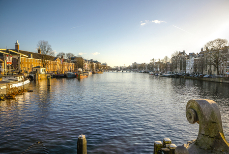 AMSTERDAM, NETHERLANDS - JANUARY 10, 2017: Famous vintage buildings & chanels of Amsterdam city at sun set. General landscape view. January 10, 2017 - Amsterdam - Netherlands.のeditorial素材