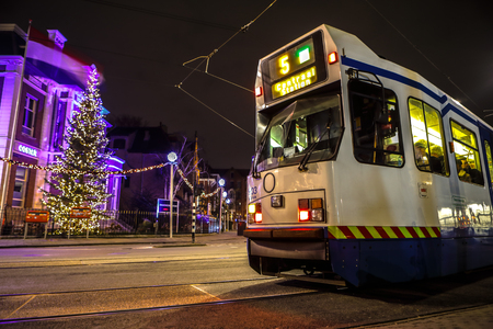 AMSTERDAM, NETHERLANDS - JANUARY 09, 2017: Blurred silhouette of moving tram in Amsterdam city at night. January 09, 2017 in Amsterdam - Netherland.のeditorial素材