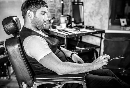 Elegant young man in barbershop. Black-white photo.の写真素材