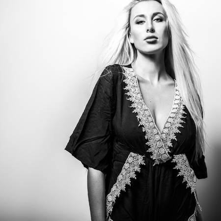 Beautiful sexy blond woman pose against studio background. Black-white photo.の写真素材