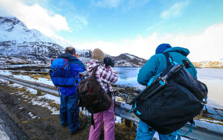Group of travel photographers doing pictures outdoor at evening time. Lofoten islands. Beautiful Norway landscape.の写真素材