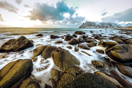 Ancient stones on the shores of cold Norwegian Sea at evening time. Lofoten islands. Beautiful Norway landscape.の写真素材