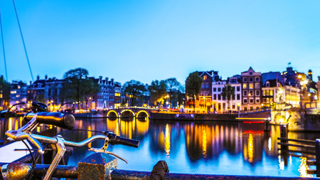 The most famous canals and embankments of Amsterdam city during sunset. General view of the cityscape and traditional Netherlands architecture.の写真素材
