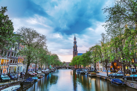 The most famous canals and embankments of Amsterdam city during sunset. General view of the cityscape and traditional Netherlands architecture.のeditorial素材