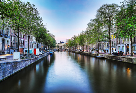 The most famous canals and embankments of Amsterdam city during sunset. General view of the cityscape and traditional Netherlands architecture.のeditorial素材