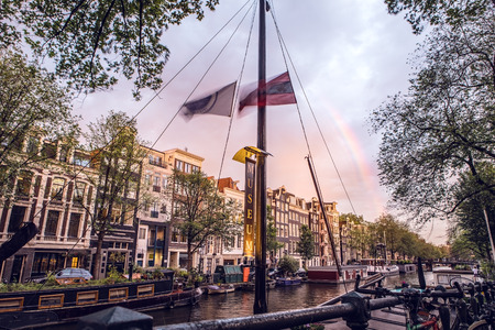 The most famous canals and embankments of Amsterdam city during sunset. General view of the cityscape and traditional Netherlands architecture.のeditorial素材