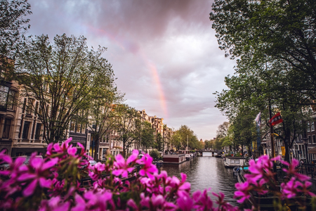 The most famous canals and embankments of Amsterdam city during sunset. General view of the cityscape and traditional Netherlands architecture.のeditorial素材