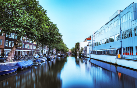 The most famous canals and embankments of Amsterdam city during sunset. General view of the cityscape and traditional Netherlands architecture.のeditorial素材