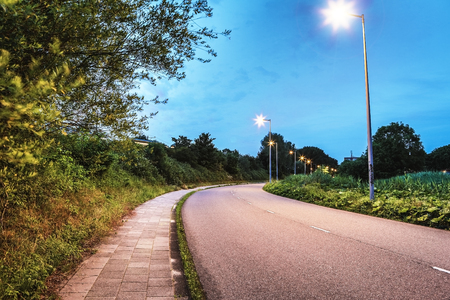 Asphalt road outside the city at twilight time.