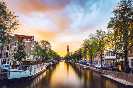 The most famous canals and embankments of Amsterdam city during sunset. General view of the cityscape and traditional Netherlands architecture.のeditorial素材