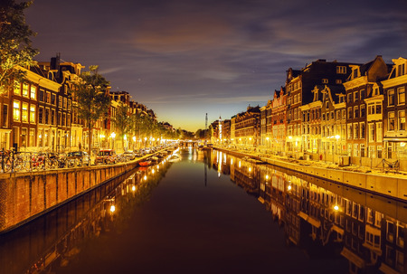 The most famous canals and embankments of Amsterdam city at night. General view of the cityscape and traditional Netherlands architecture.のeditorial素材