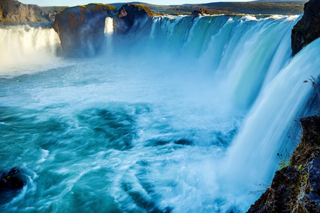 Picturesque landscape of a mountain waterfall and traditional nature of Iceland.