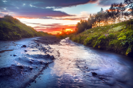 Picturesque landscape of a mountain river with traditional nature of Iceland at amazing sun set.の写真素材
