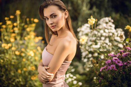Outdoors portrait of beautiful young woman in casual clothes posing in autumn garden.の写真素材