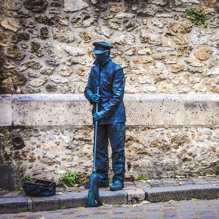 PARIS, FRANCE - NOVEMBER 11, 2017: Street performance of actor stylized as sculpture. at rainy autumn evening on November 11 in Paris - France.のeditorial素材