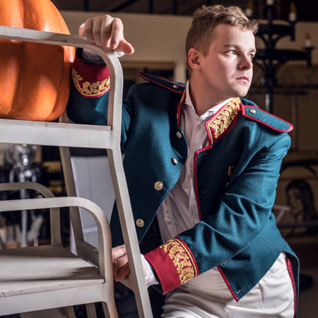 Actor dressed historical costume in interior of old theater.