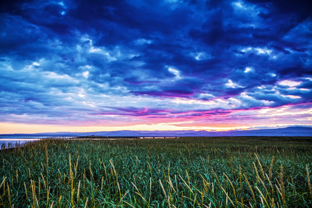 Picturesque landscape of a meadow with traditional nature of Iceland with amazing red sun set.の写真素材