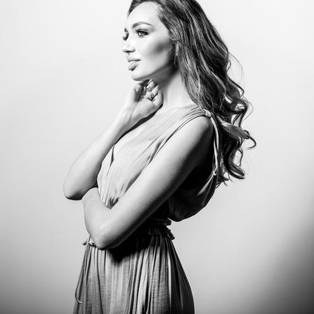 Young beautifull woman in silk dress black-white studio portrait.の写真素材