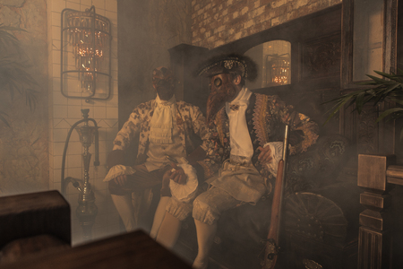 Actors in Steam punk masks and antique costumes indoor.