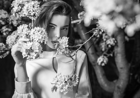 Outdoors portrait of beautiful young woman posing in summer garden. Black-white photo.の写真素材