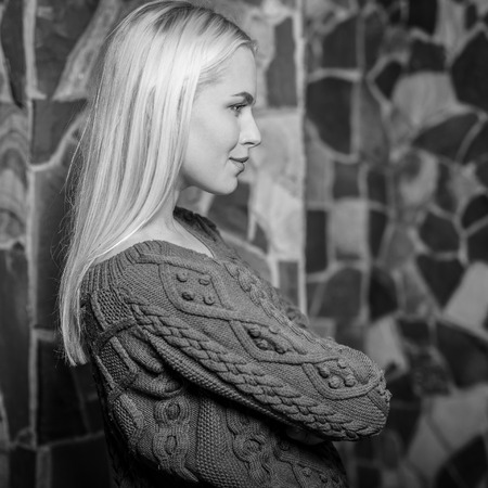 Young blond beauty woman against house interior. Black-white photo.の写真素材