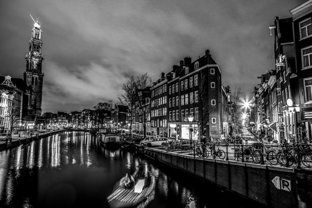 AMSTERDAM, NETHERLANDS - JANUARY 12, 2017: Beautiful night city canals of Amsterdam with moving passanger boat. January 12, 2017 in Amsterdam - Netherland.のeditorial素材