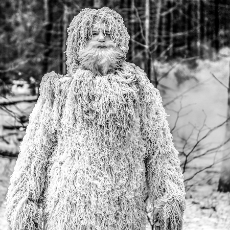 Yeti fairy tale character in winter forest. Outdoor fantasy black-white photo.
