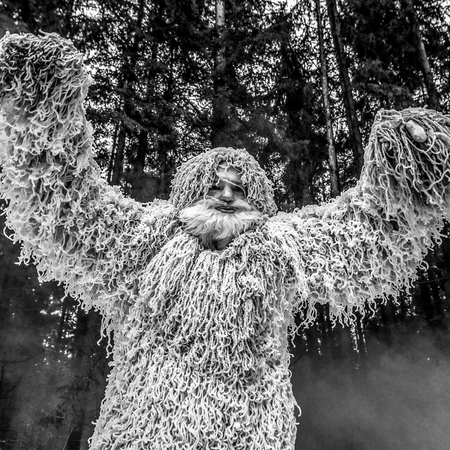 Yeti fairy tale character in winter forest. Outdoor fantasy black-white photo.
