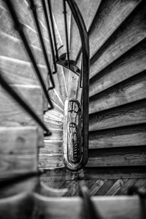 Black-white photo of wooden spiral staircase in old building, Paris, France.の写真素材
